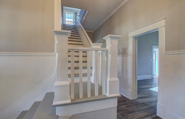 staircase with hardwood / wood-style floors and ornamental molding