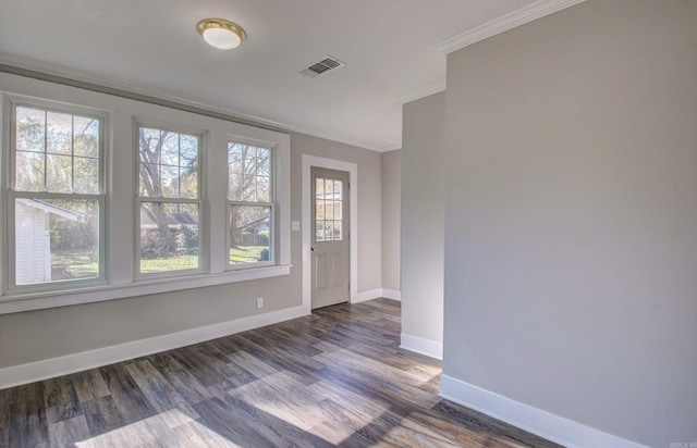 unfurnished room featuring dark hardwood / wood-style flooring, ornamental molding, and a wealth of natural light