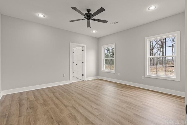 spare room with plenty of natural light, ceiling fan, and light wood-type flooring