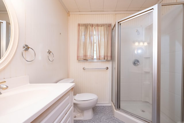 bathroom with wood walls, a shower with door, vanity, and toilet