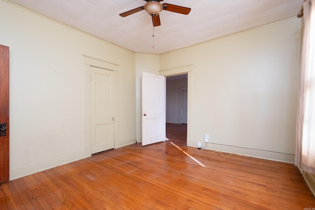 empty room featuring wood-type flooring, ceiling fan, and crown molding