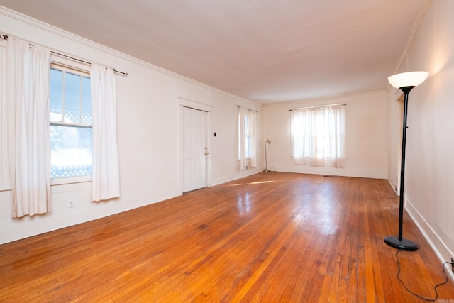 empty room with wood-type flooring and crown molding