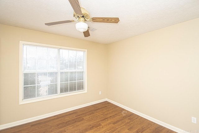 unfurnished room with ceiling fan, wood-type flooring, and a textured ceiling