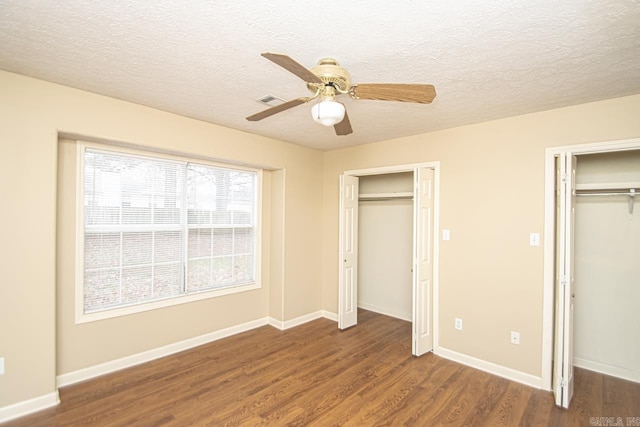 unfurnished bedroom featuring a textured ceiling, dark hardwood / wood-style floors, and ceiling fan