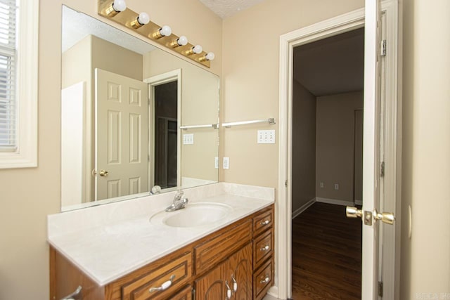 bathroom with wood-type flooring, vanity, and a textured ceiling