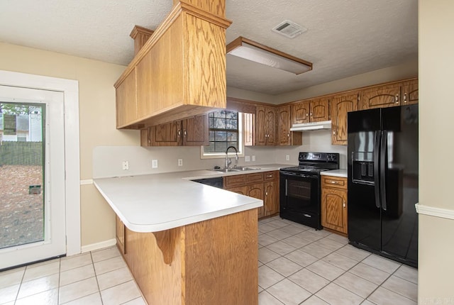 kitchen with black appliances, plenty of natural light, sink, and a textured ceiling