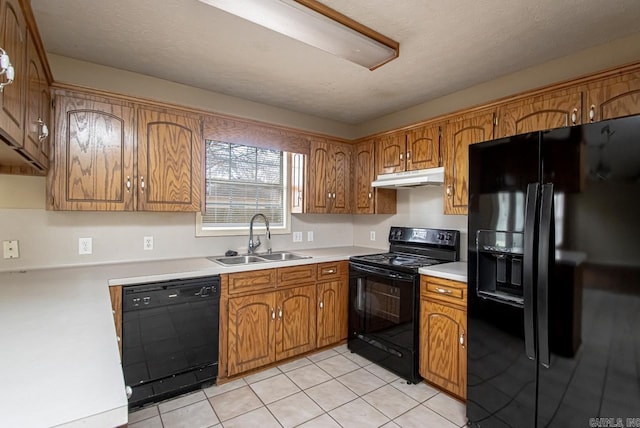 kitchen featuring sink, light tile patterned flooring, black appliances, and a textured ceiling