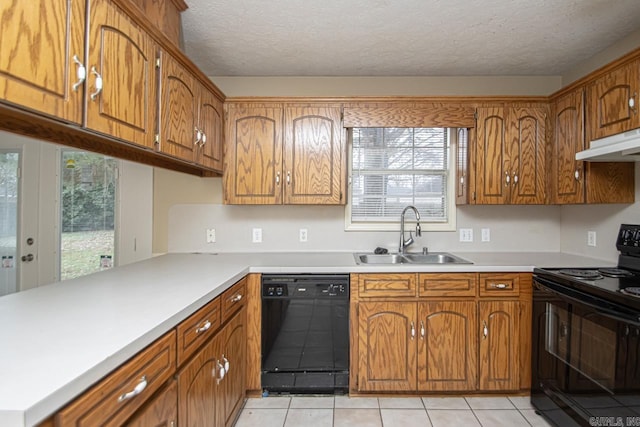 kitchen featuring sink, kitchen peninsula, a textured ceiling, light tile patterned floors, and black appliances