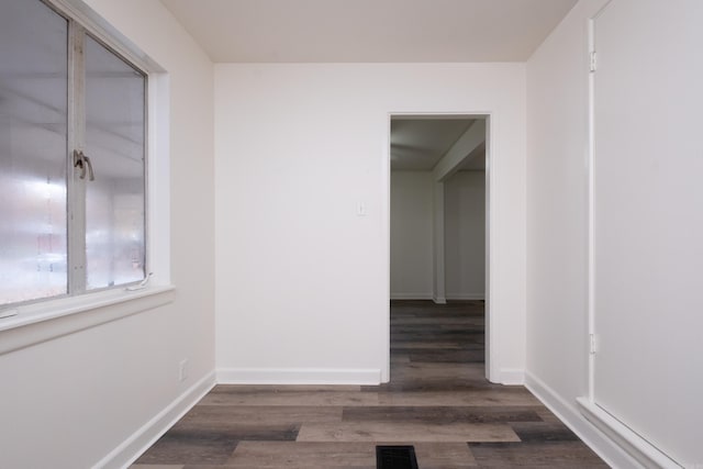 unfurnished room with dark wood-type flooring