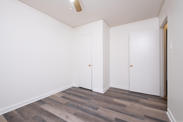 unfurnished bedroom with a closet, dark hardwood / wood-style floors, ceiling fan, and crown molding