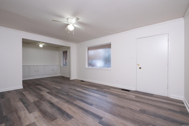 empty room with crown molding, ceiling fan, and dark wood-type flooring