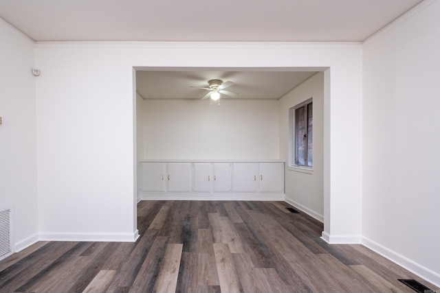 empty room featuring crown molding, ceiling fan, and dark wood-type flooring