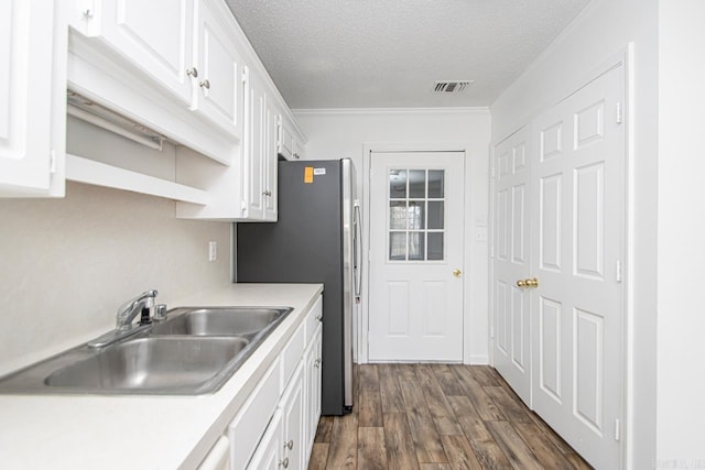 kitchen featuring white cabinets, dark hardwood / wood-style floors, sink, and a textured ceiling