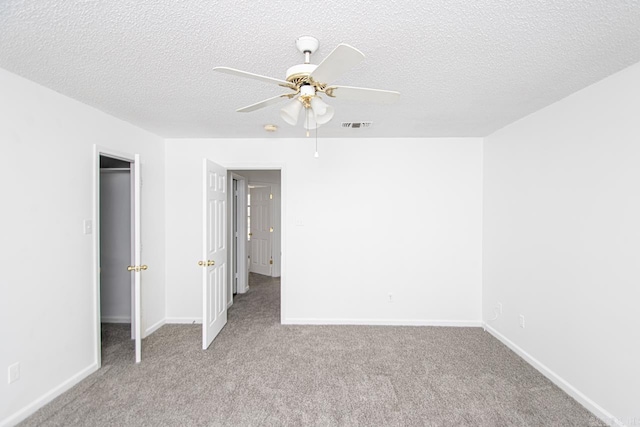 unfurnished bedroom with ceiling fan, a closet, light colored carpet, and a textured ceiling