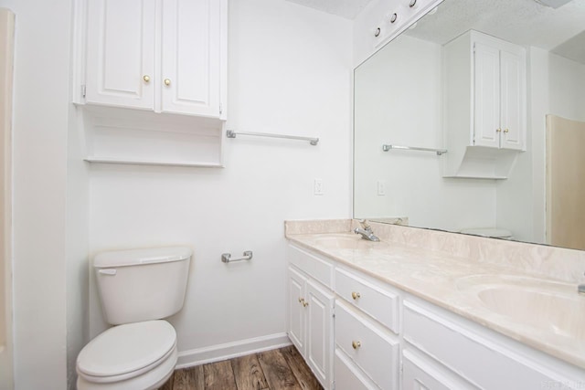 bathroom with vanity, wood-type flooring, and toilet