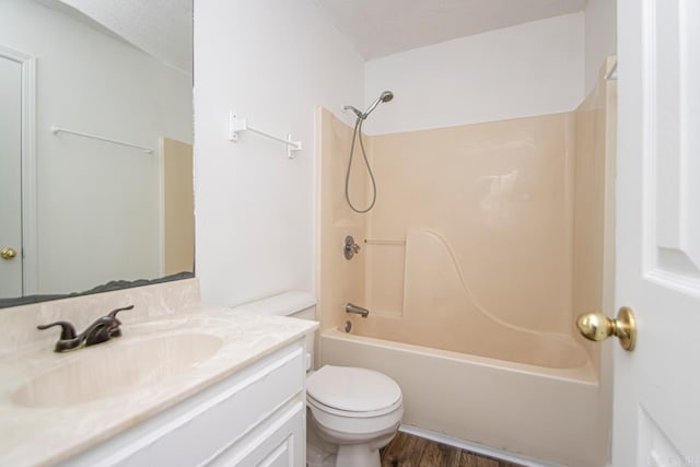 full bathroom featuring hardwood / wood-style floors, vanity, toilet, a textured ceiling, and tub / shower combination