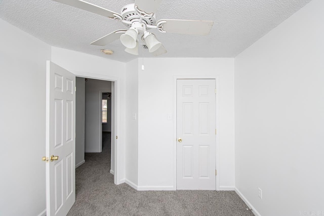 unfurnished bedroom with a textured ceiling, ceiling fan, light carpet, and a closet