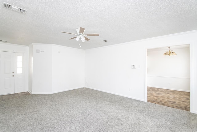 spare room featuring carpet, a textured ceiling, ceiling fan with notable chandelier, and crown molding