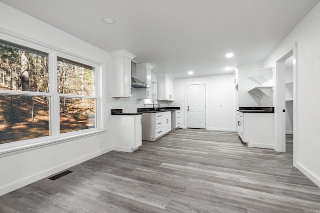 kitchen with white cabinetry, sink, and light hardwood / wood-style flooring