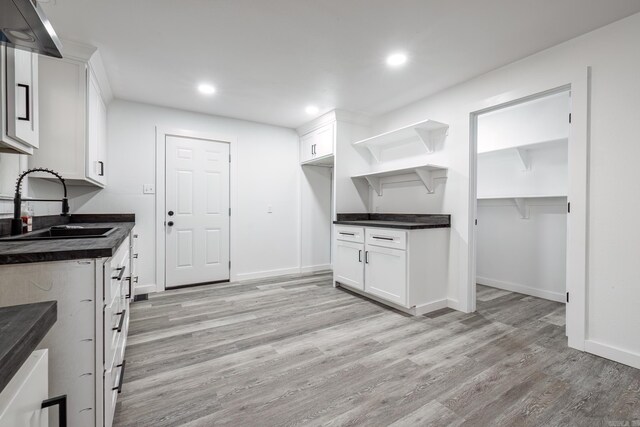 kitchen featuring white cabinetry, sink, and light wood-type flooring