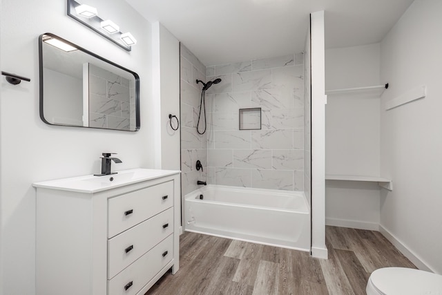 full bathroom featuring hardwood / wood-style flooring, toilet, vanity, and tiled shower / bath