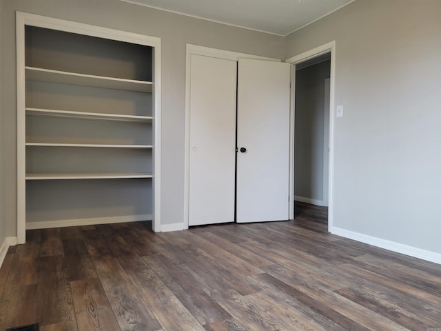 unfurnished bedroom with dark hardwood / wood-style flooring