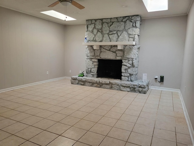 unfurnished living room with a fireplace, light tile patterned floors, ceiling fan, and ornamental molding