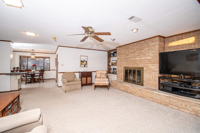 living room with light carpet, a brick fireplace, ceiling fan, ornamental molding, and a textured ceiling