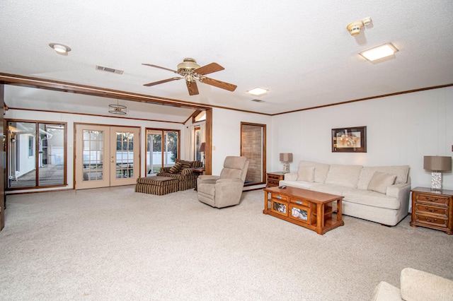 carpeted living room with french doors, a textured ceiling, ceiling fan, and crown molding