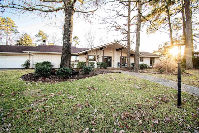 ranch-style house with a garage and a front lawn