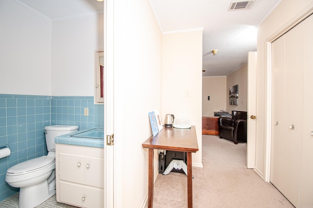 bathroom featuring crown molding, vanity, a textured ceiling, and toilet