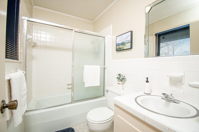 full bathroom with vanity, combined bath / shower with glass door, toilet, ornamental molding, and tile walls