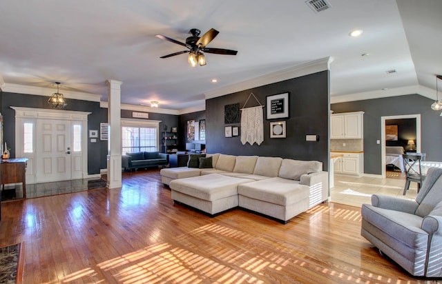 living room with ornate columns, ornamental molding, vaulted ceiling, ceiling fan, and light hardwood / wood-style flooring