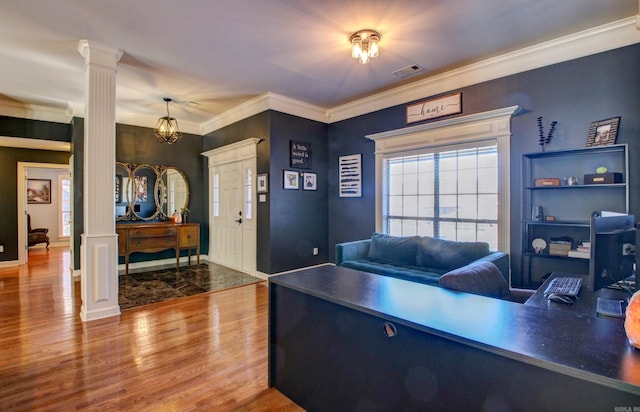 office area with decorative columns, hardwood / wood-style flooring, and ornamental molding