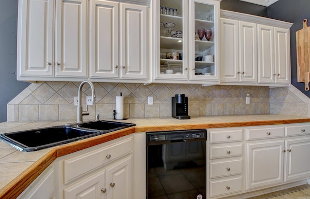 kitchen with tile countertops, dishwasher, sink, tasteful backsplash, and white cabinetry