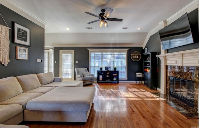 living room featuring vaulted ceiling, ceiling fan, crown molding, a fireplace, and hardwood / wood-style floors