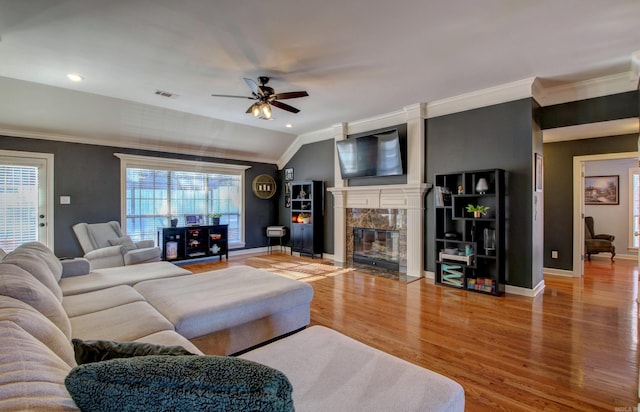 living room with plenty of natural light, ceiling fan, lofted ceiling, and a premium fireplace