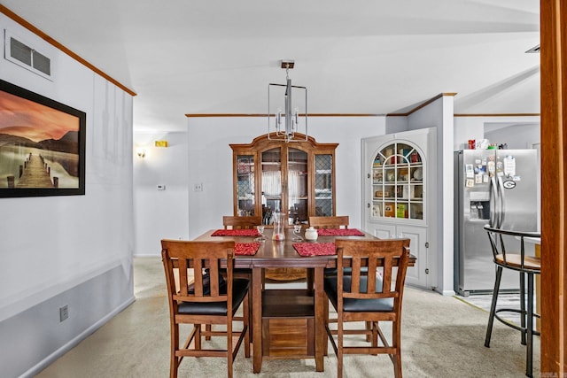 dining room featuring ornamental molding and light carpet