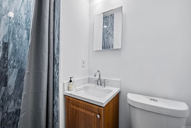 bathroom with vanity, curtained shower, and toilet