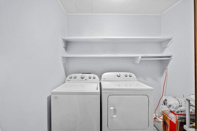 laundry room featuring crown molding and washing machine and clothes dryer