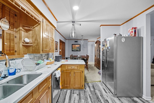 kitchen featuring crown molding, sink, hanging light fixtures, kitchen peninsula, and stainless steel appliances