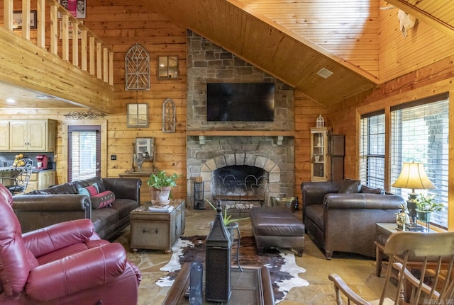 living room with wood walls, a fireplace, high vaulted ceiling, and wooden ceiling