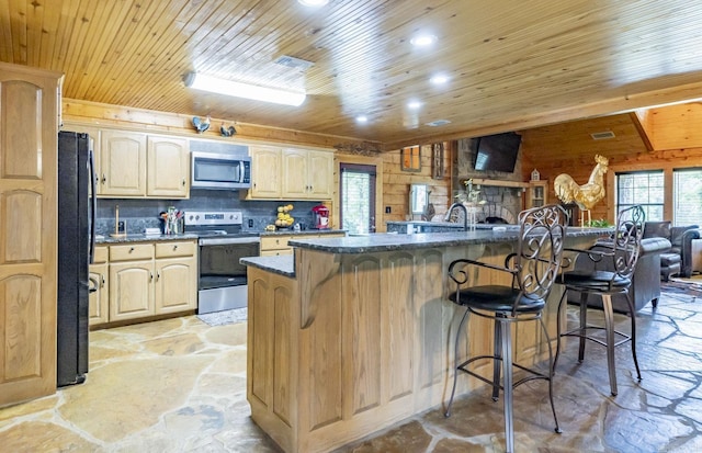 kitchen featuring a center island, stainless steel appliances, a breakfast bar area, and tasteful backsplash