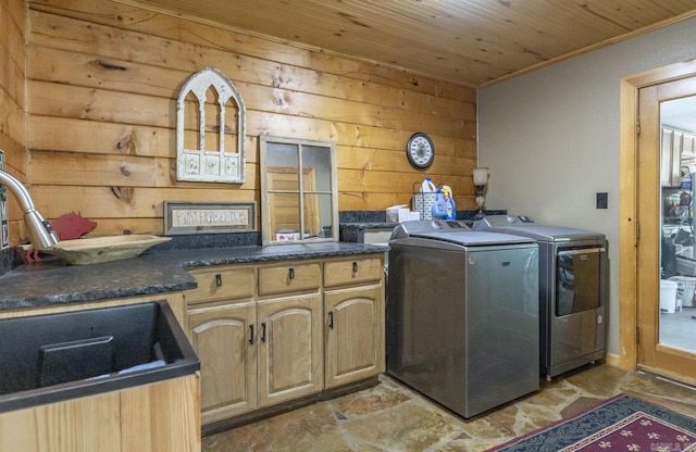 laundry area featuring wood walls, cabinets, wood ceiling, and washing machine and clothes dryer