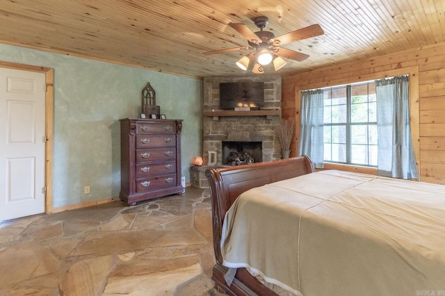 bedroom with a fireplace, ceiling fan, wood walls, and wood ceiling