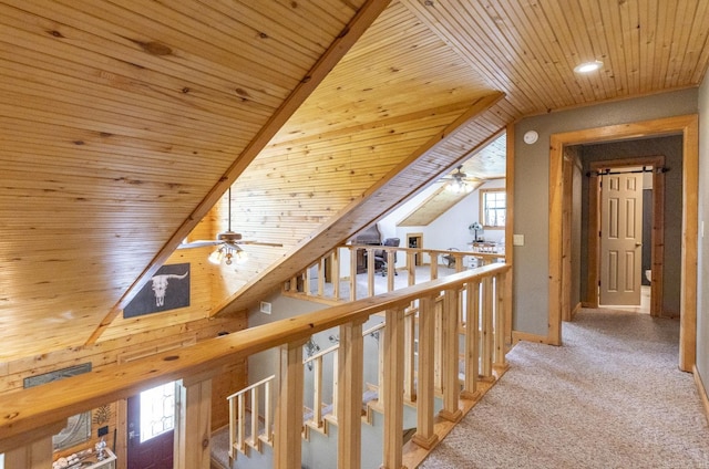 hall featuring carpet flooring, wood ceiling, and vaulted ceiling