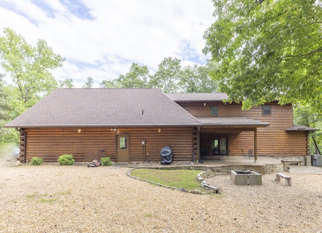 back of property featuring an outdoor fire pit and a patio