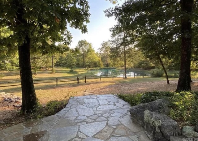 view of property's community with a water view and a patio