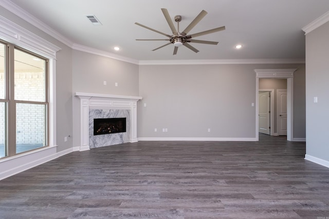 unfurnished living room featuring ceiling fan, a high end fireplace, dark wood-type flooring, and ornamental molding