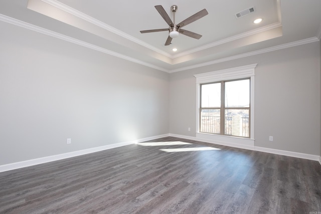 spare room with ornamental molding, a tray ceiling, ceiling fan, and dark wood-type flooring